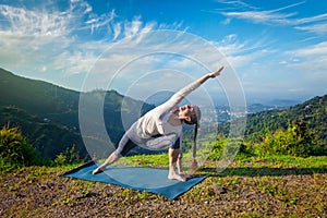 Woman practices yoga asana outdoors