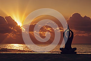 Woman practices yoga and meditation on the beach at sunset, generative AI