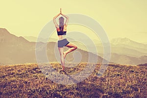 Woman practices yoga in the mountains