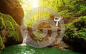 Woman practices yoga in nature, the waterfall