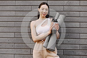 Woman practicing advanced yoga against a dark urban wall