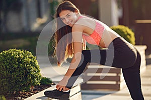 Woman practicing advanced yoga in a summer city