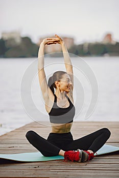 Woman practicing advanced yoga by the water