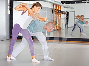 Woman practicing basic self defense movements with male partner