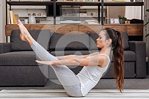 Woman practicing boat pose at home in