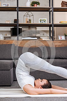 Woman practicing boat pose at home in