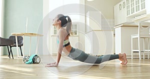 Woman practicing Downward Facing Dog pose in yoga sport exercise at home.