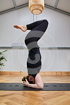 woman practicing inverted yoga on the head. Salamba Sirsasana