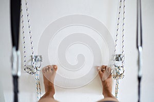 Woman practicing iyengar yoga using wall ropes in studio