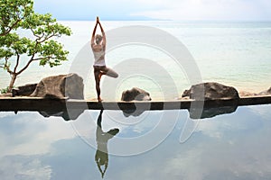 Woman practicing morning meditation Yoga at the beach