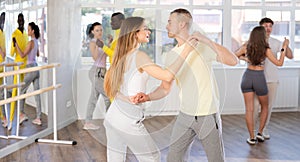 Woman practicing passionate samba with man in dance class