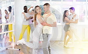 Woman practicing passionate samba with man in dance class