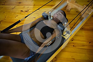 Woman practicing pilates on reformer photo