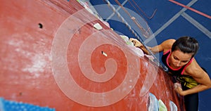 Woman practicing rock climbing in fitness studio 4k