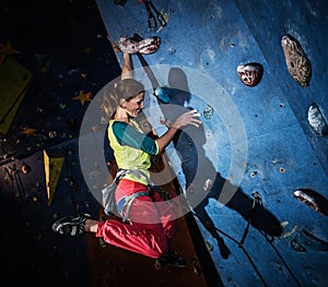 Woman practicing rock-climbing on a rock wall