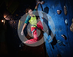 Woman practicing rock-climbing on a rock wall