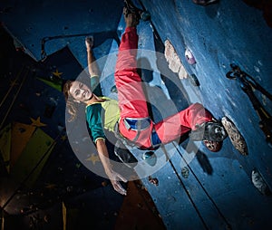 Woman practicing rock-climbing on a rock wall