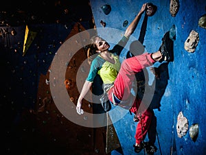 Woman practicing rock-climbing on a rock wall