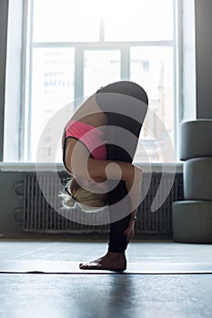 Woman practicing standing forward bend yoga pose