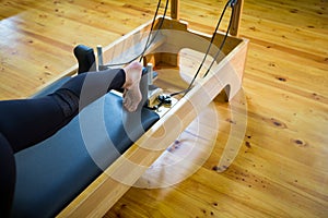 Woman practicing stretching exercise on reformer