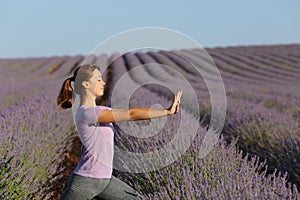Woman practicing tai chi exercises in lavender field