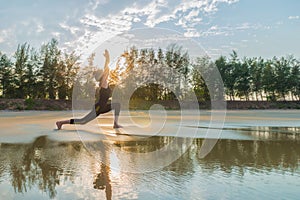 Woman practicing Warrior yoga pose outdoors