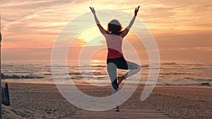 Woman practicing yoga on beach, sport outdoors