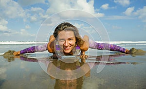 Young happy and attractive girl doing flexibility exercise with legs split  on sand in wellness harmony health care and fitness