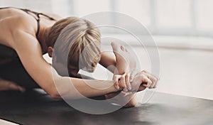 Woman practicing yoga in class, young woman doing exercises at home. Training, fitness, workout concept