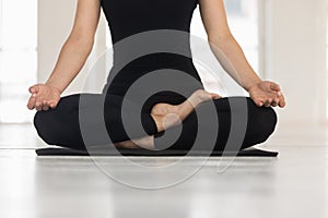 Woman practicing yoga, doing Padmasana exercise, Lotus pose close up
