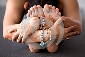 Woman practicing yoga, doing Seated forward bend, paschimottanas photo