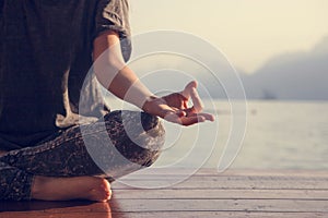 Woman practicing yoga by a lake