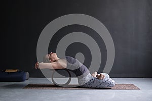 Woman practicing yoga in lotus fish posture Matsyasana