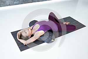 Woman practicing yoga lying in Reclined Butterfly exercise photo