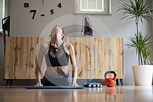 Woman practicing yoga making a cobra pose at home