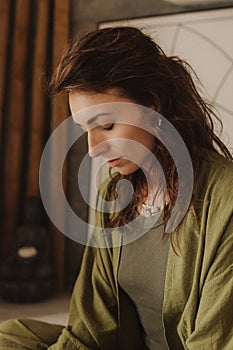 Woman practicing yoga and meditation at home sitting in lotus pose on yoga mat, relaxed with closed eyes. Mindful meditation