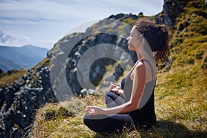 Woman practicing yoga on mountain
