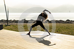 Woman practicing yoga in park.