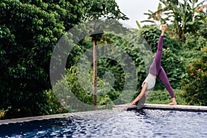 Woman practicing yoga performing yoga-asanas outdoors.
