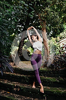 Woman practicing yoga performing yoga-asanas outdoors.