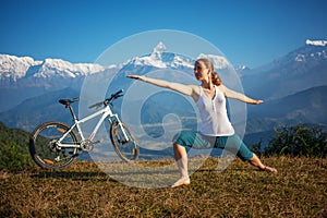 Woman practicing yoga, relaxing after riding bikes