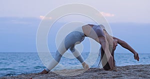 Woman practicing yoga in the sea during a sunset. Mindfulness, Meditation