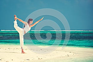 Woman practicing yoga at seashore