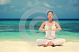 Woman practicing yoga at seashore