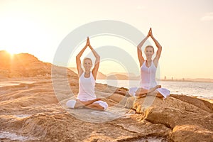 woman practicing yoga at seashore