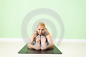 Woman practicing yoga sitting in Paschimottanasana Seated Forwa