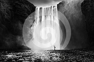 Woman practicing yoga at the Skogafoss waterfall