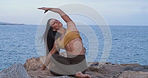 Woman practicing yoga on some rocks with the sea on the horizon.Mindfulness, Meditation