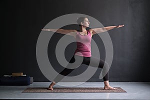 Woman practicing yoga, standing in Warrior Two exercise, Virabhadrasana II pose