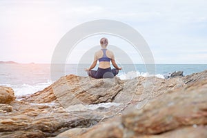 The woman practicing yoga sunset on the beach.